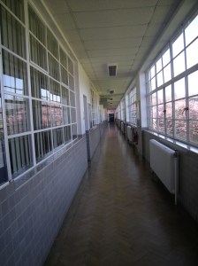 This dull grey corridor was originally painted two light shades of yellow, to enhance teh airy feel of the school